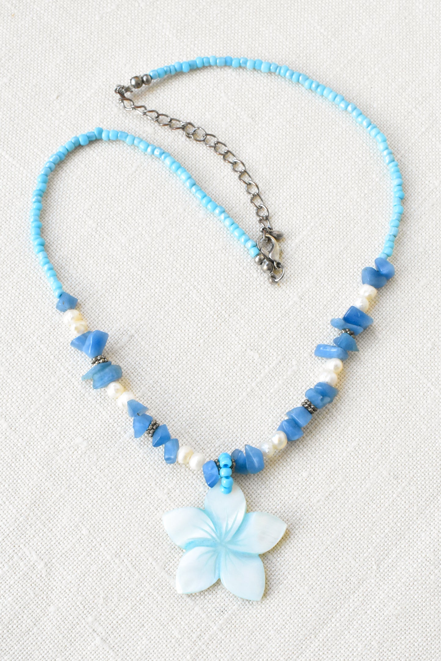 Flower pendant necklace with pearls, shell and blue gemstones