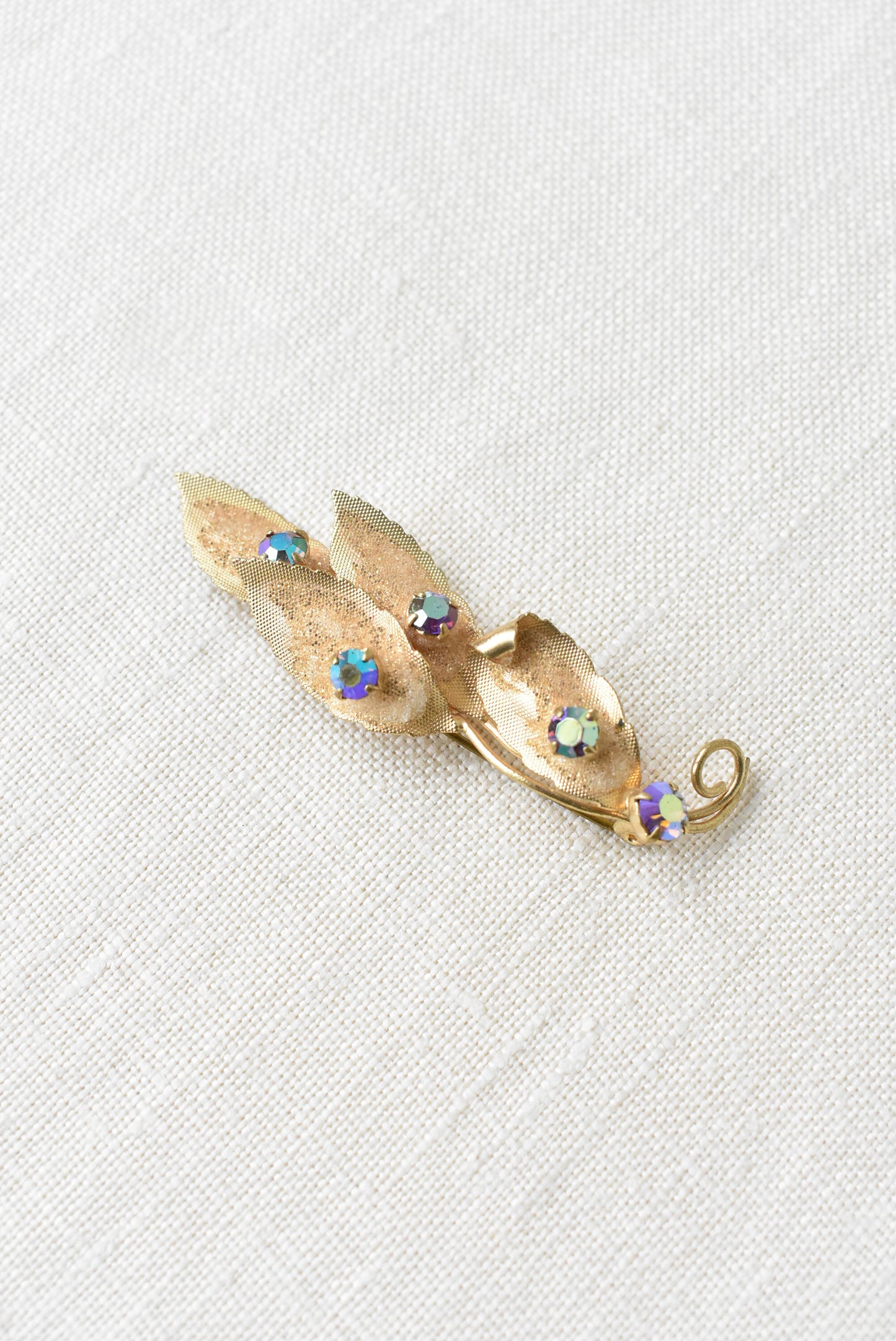Glitery brassy molded leaf and diamante brooch