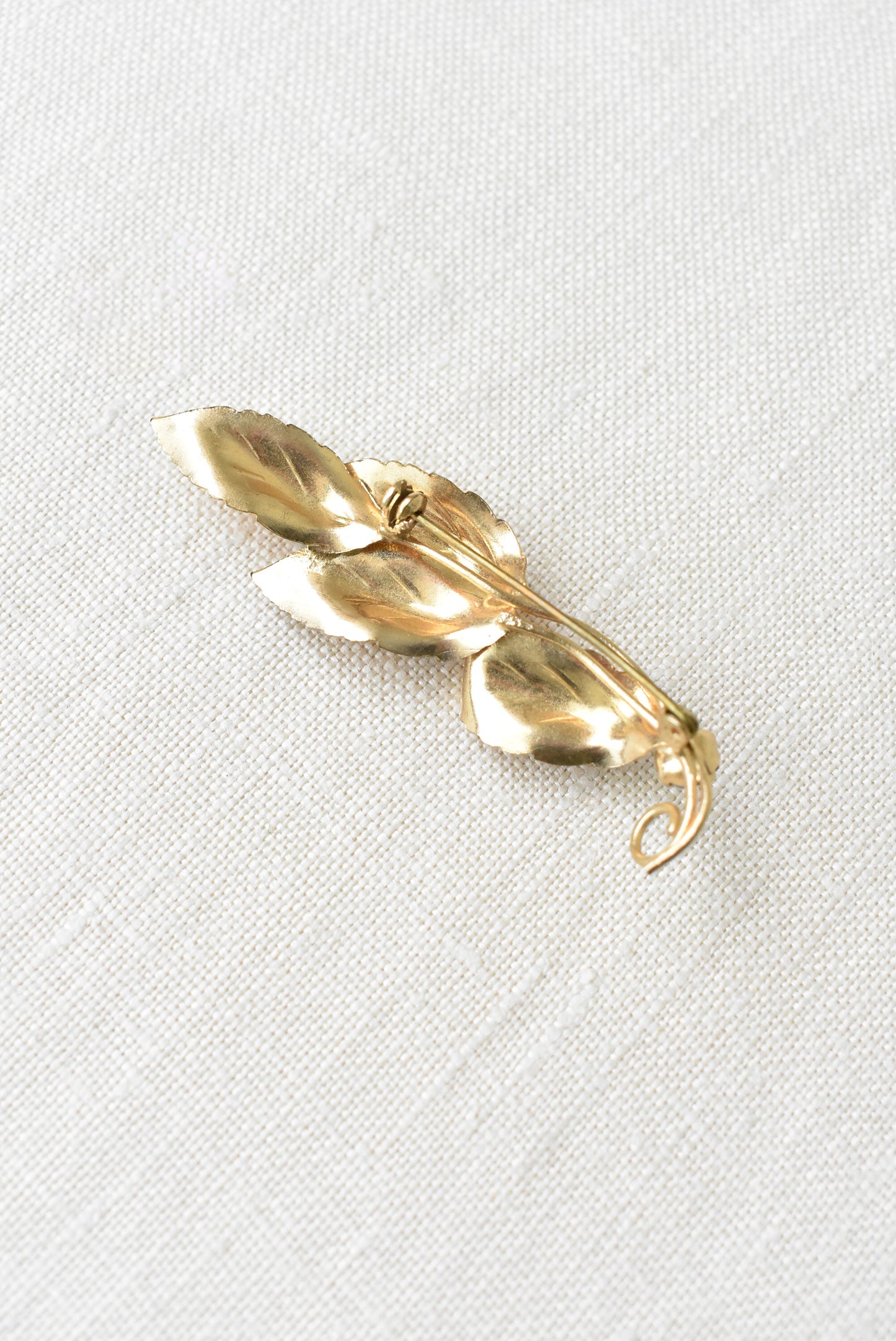 Glitery brassy molded leaf and diamante brooch