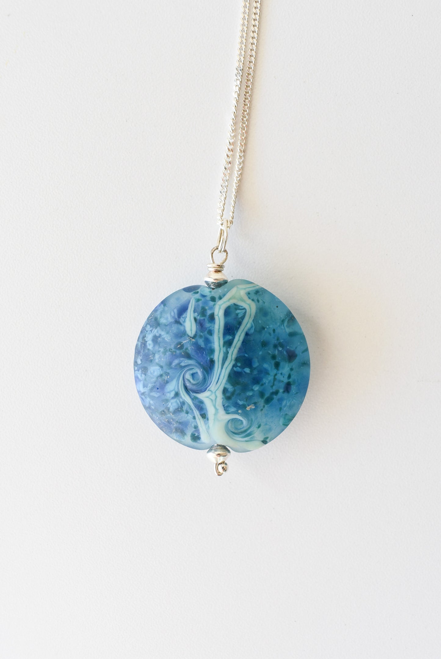 Round blue pendant on silver chain