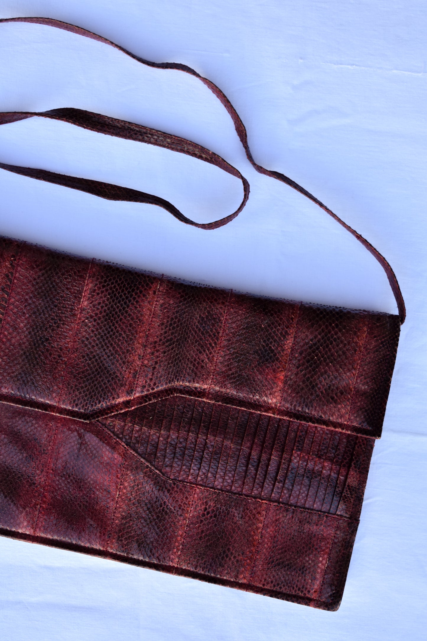 Maroon snakeskin clutch with strap