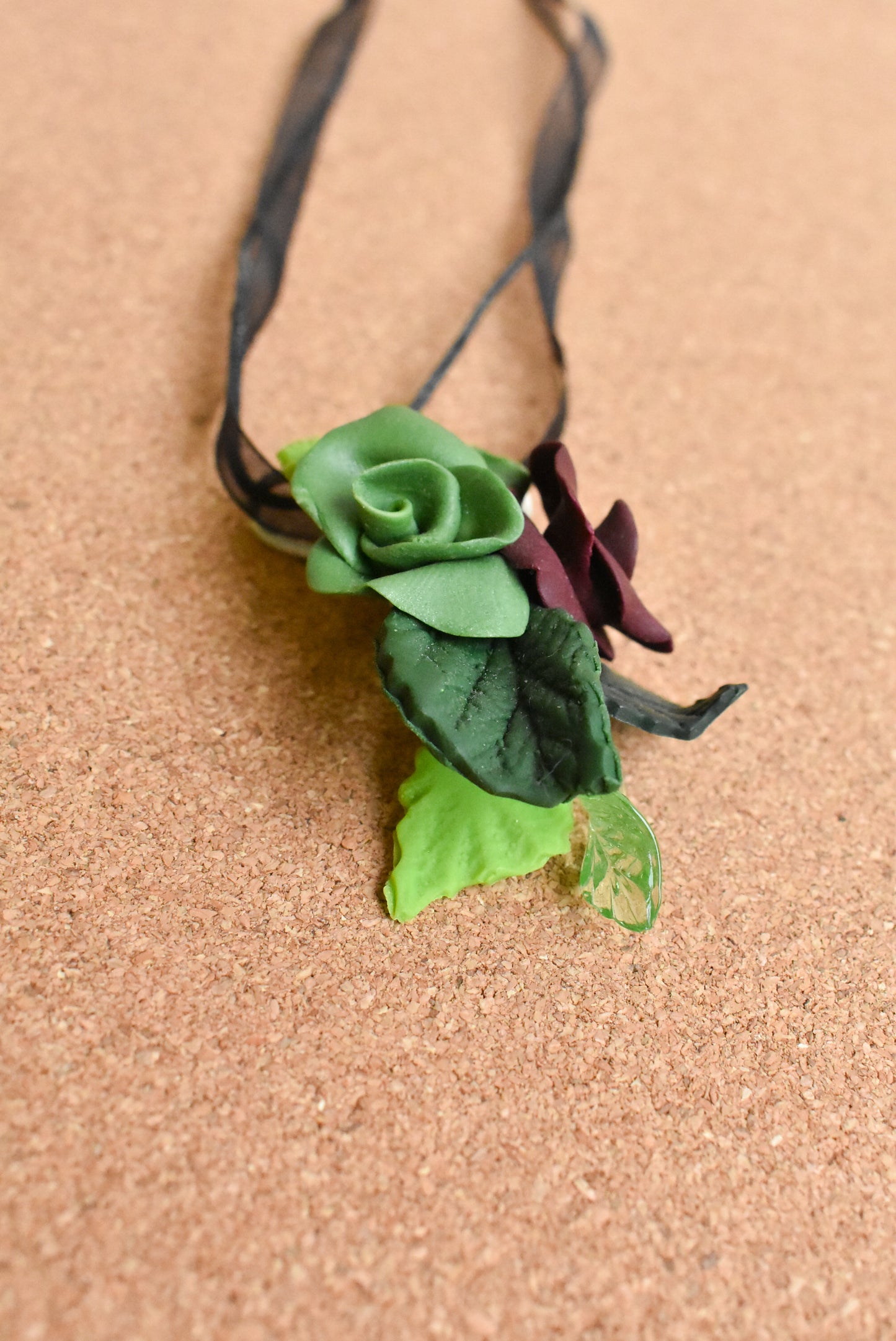Ceramic flower ribbon necklace with green and purple flowers